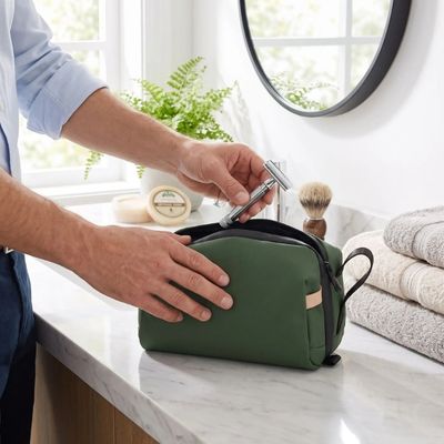 Homme met rasoir dans sa trousse de toilette de voyage homme